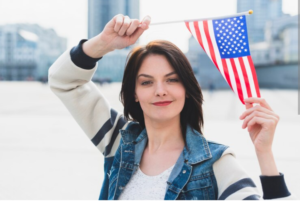 A lady holding a US flag. Image for illustrating the J1 visa