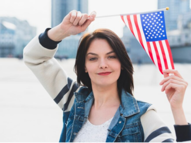 A lady holding a US flag. Image for illustrating the J1 visa